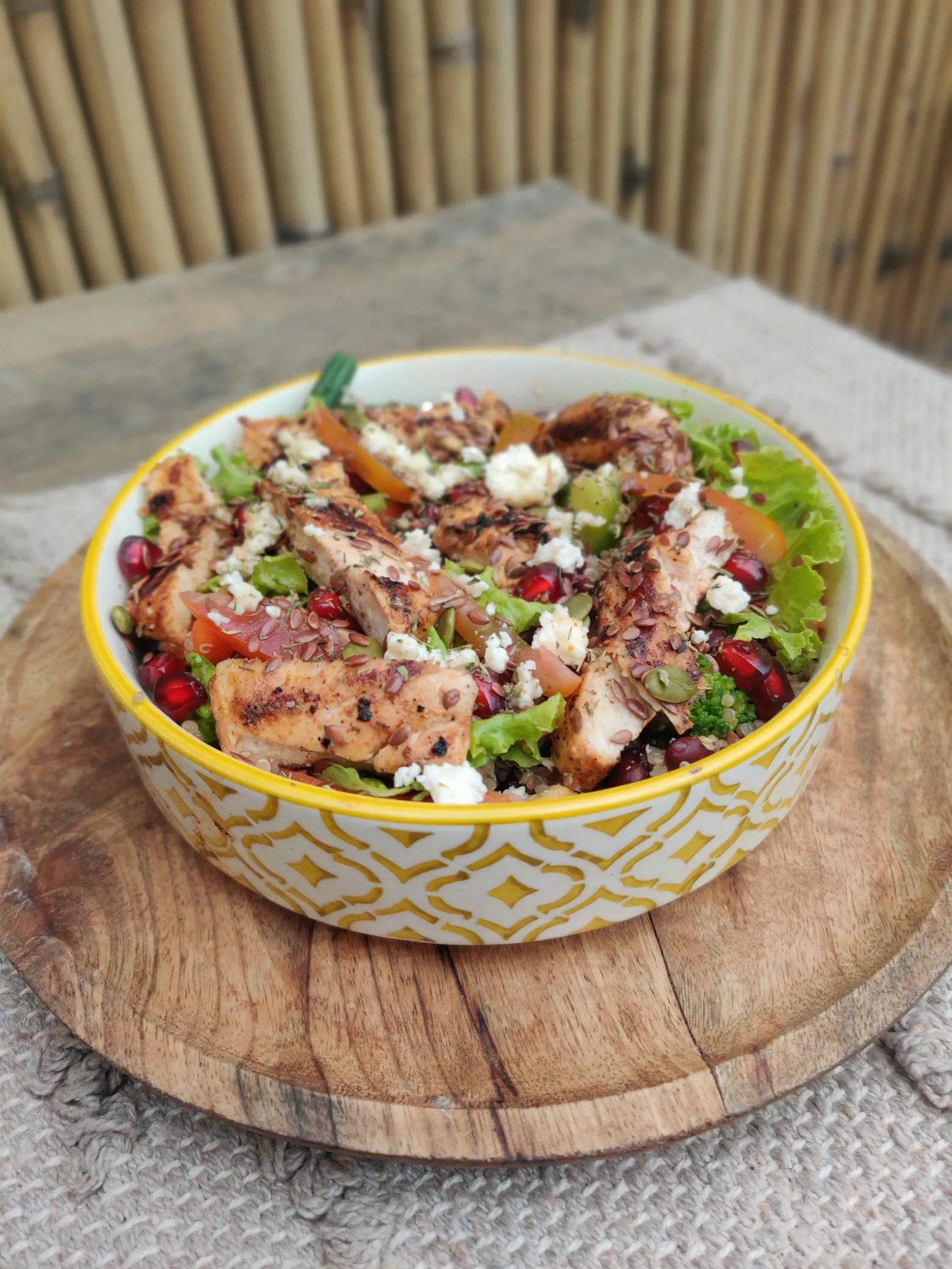 Grilled chicken salad lunch bowl from Clean & Green Meals — fresh greens, pomegranate, watermelon, feta
